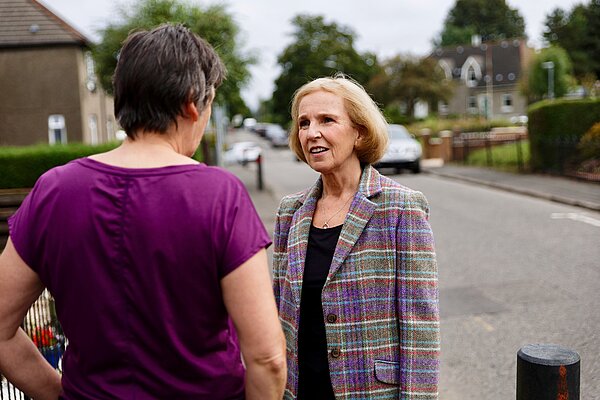 Susan chatting with a local resident on the street