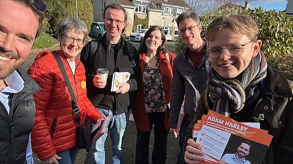 Adam Harley out with a group of Lib Dem campaigners holding leaflets.