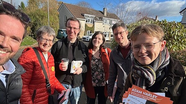Adam Harley out with a group of Lib Dem campaigners holding leaflets.