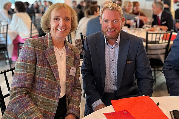 Susan Murray and Jamie Green sitting together at a table together at a lunch event.