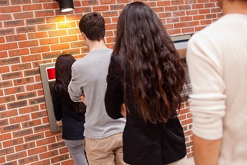 People queuing for an ATM.