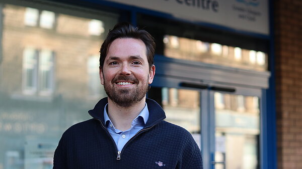 Adam Harley smiling outside a health centre
