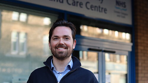 Adam Harley smiling outside a health centre