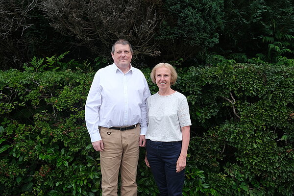 Ben Langmead standing next to Susan Murray with a hedge in the background.