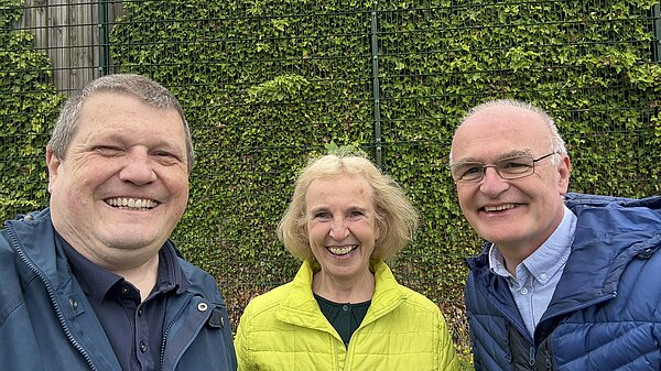 Ben Langmead, Susan Murray and Vaughan Moody together smiling with the hedge covered fence in the background.