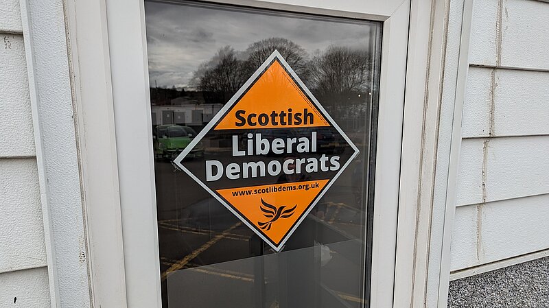 Scottish Liberal Democrat orange diamond poster on door window