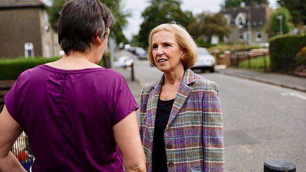 Susan Murray talking to a resident on the street