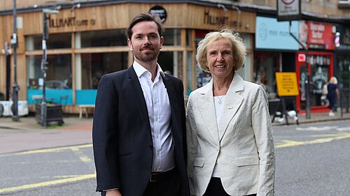 Adam Harley and Susan Murray standing together with local high street businesses in the background
