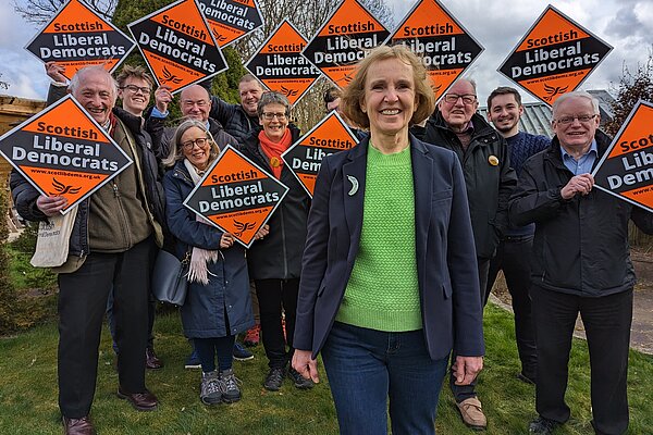 Susan standing in front of Lib Dem campaigners